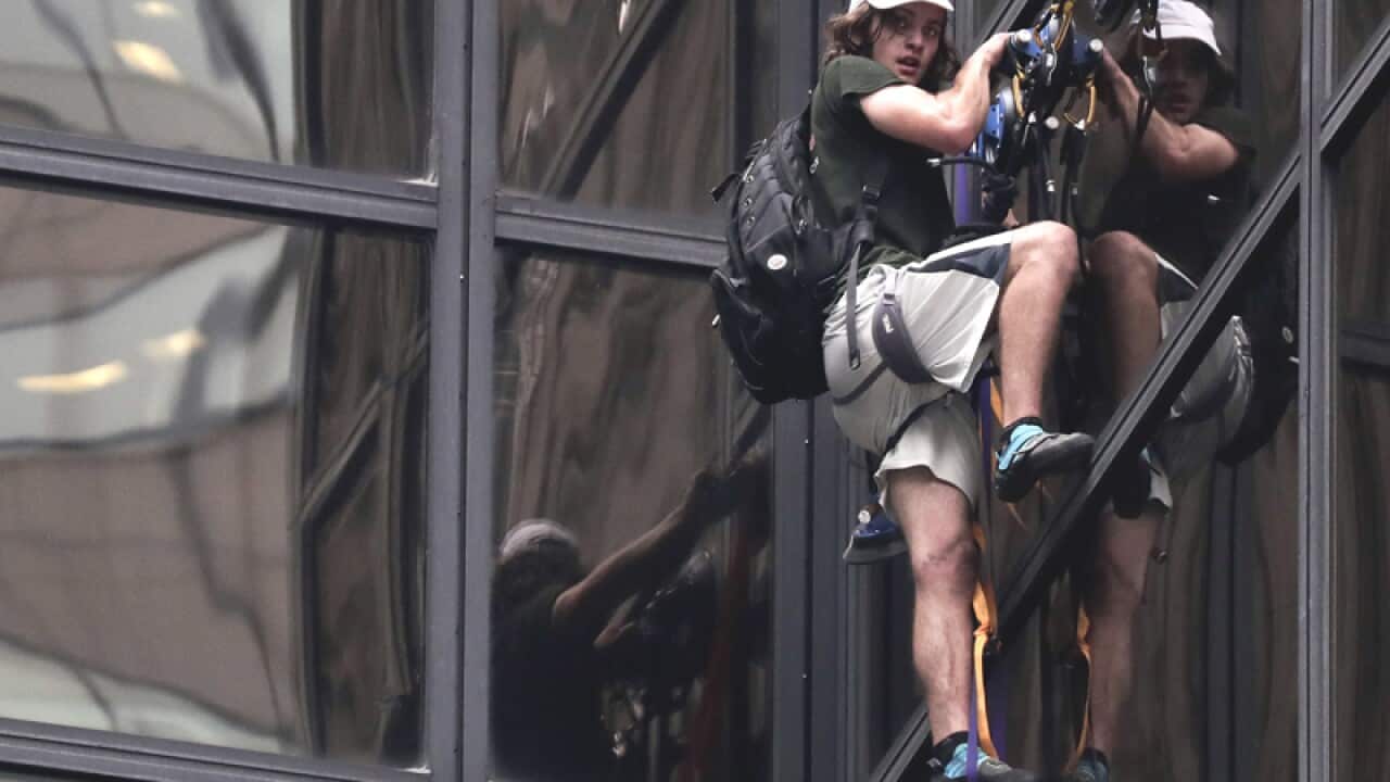 A man scales the all-glass facade of Trump Tower