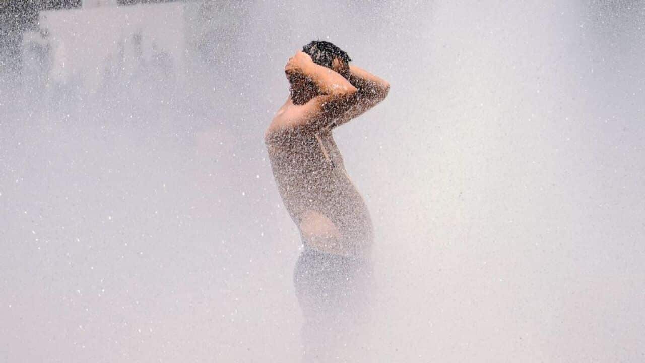 A man cools off in the Salmon Street springs fountain in Portland, Oregon on June 28, 2021