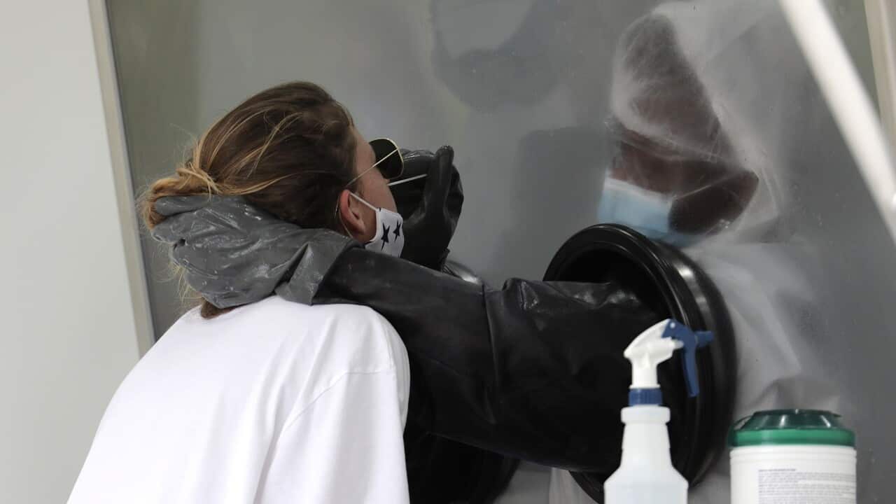 A health care worker administers a COVID-19 test in Miami.