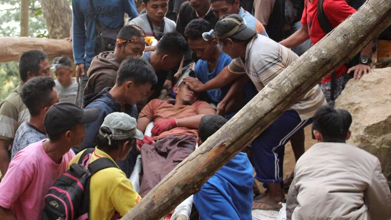 Rescuers carry a survivor from inside a collapsed mine in Bolaang Mongondow, North Sulawesi, Indonesia