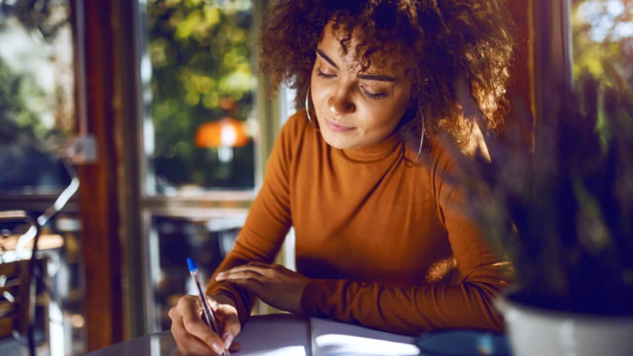 Portrait of a woman writing in a notebook