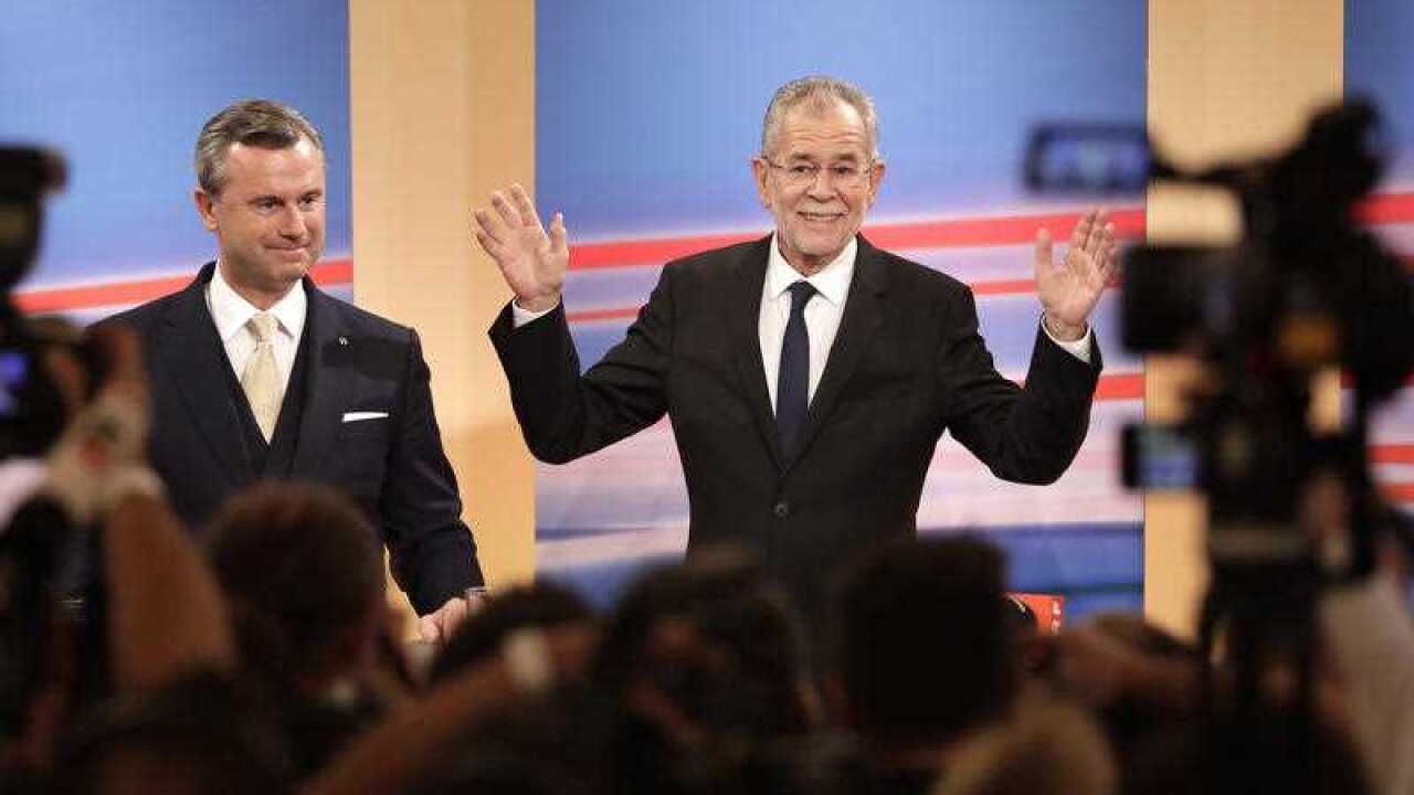 Presidential candidate Alexander Van der Bellen, right, a former leading member of the Greens Party, raises his arms beside Norbert Hofer