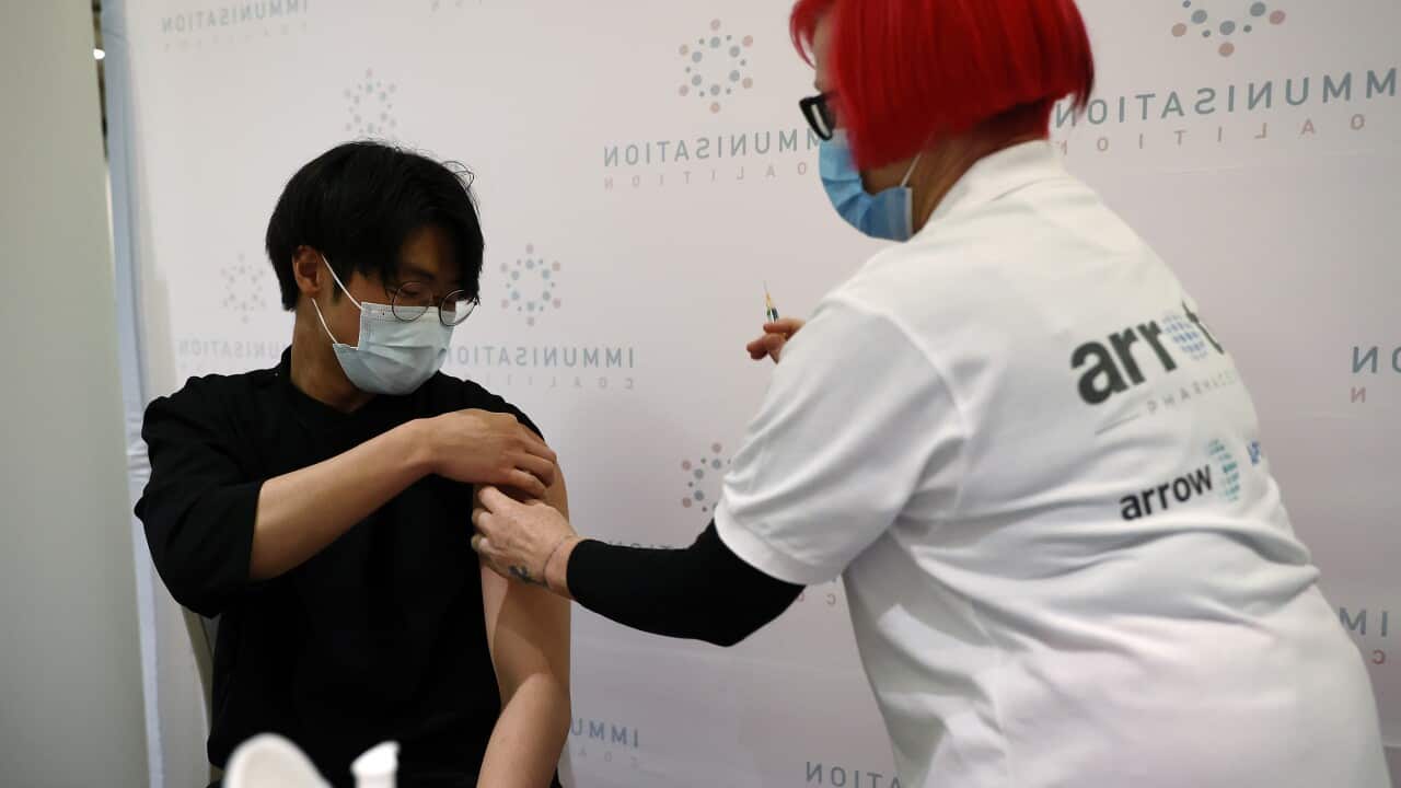 A woman gives a man an injection