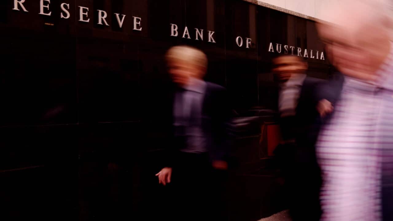 Pedestrians walk past te Reserve Bank of Australia