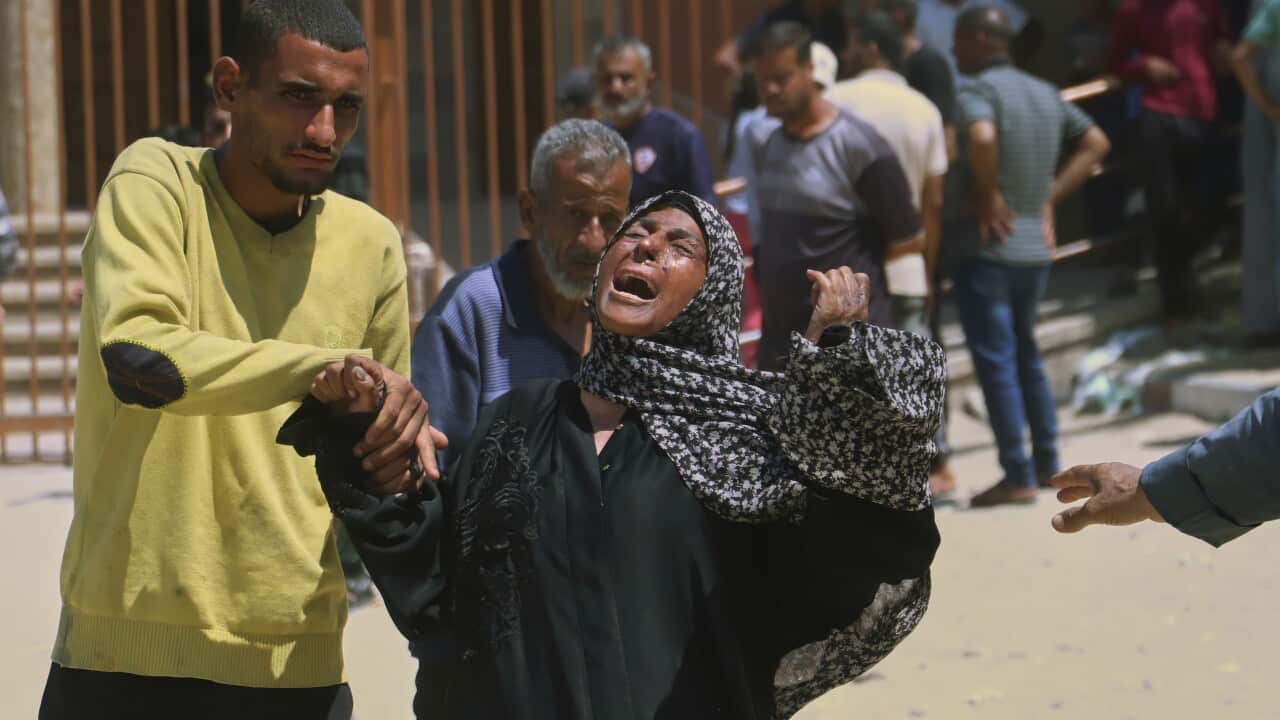 A woman crying out, as a man holds her hand.