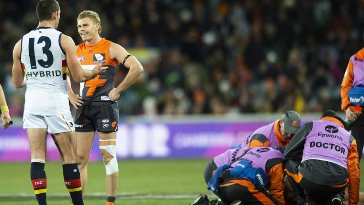 Adelaide player Taylor Walker (2L) is seen after a dangerous tackle