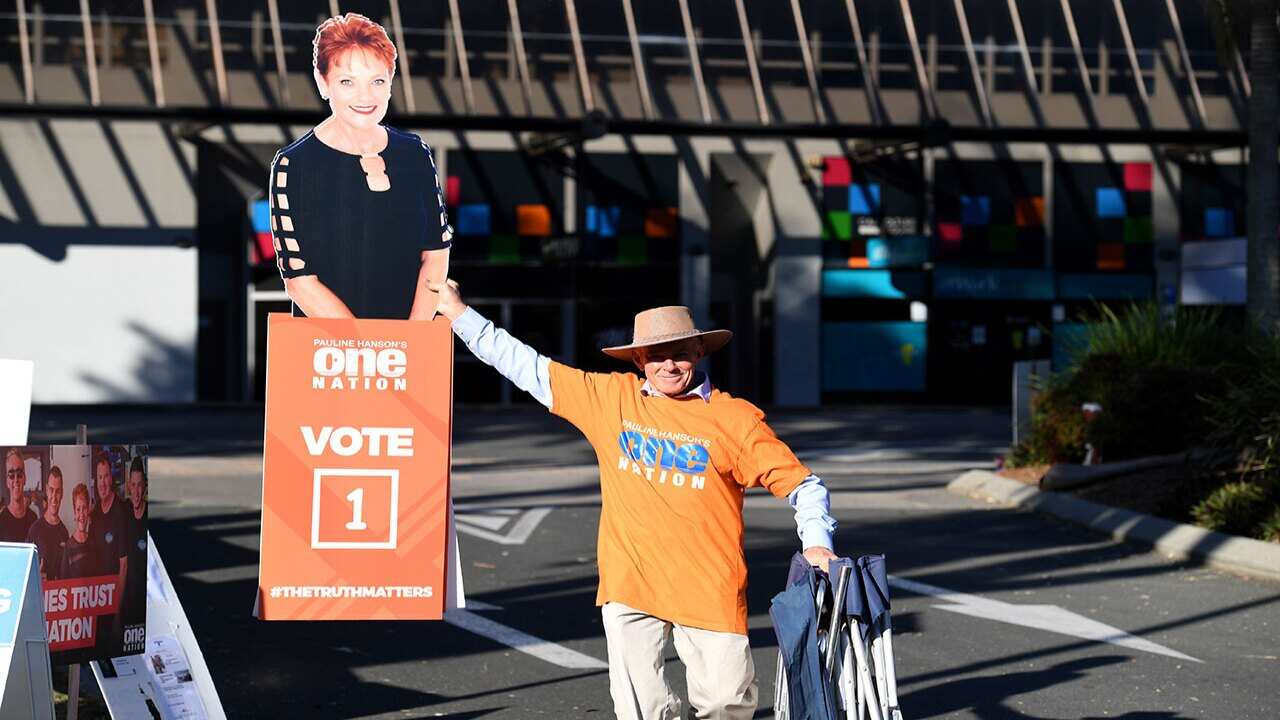 Former One Nation senator Malcolm Roberts arrives at a polling booth with a cardboard cutout of Pauline Hanson in Caboolture during the Longman by-election.