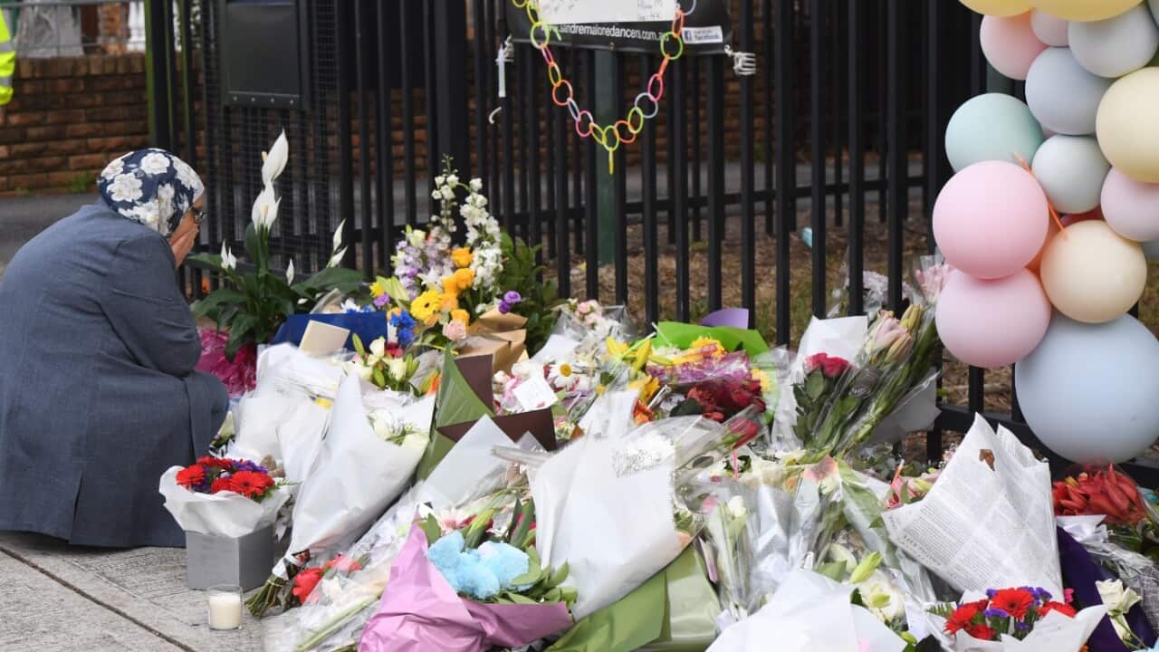 A woman reacts after placing flowers outside Banksia Road Public School in Greenacre, Sydney, Wednesday, November 8, 2017.