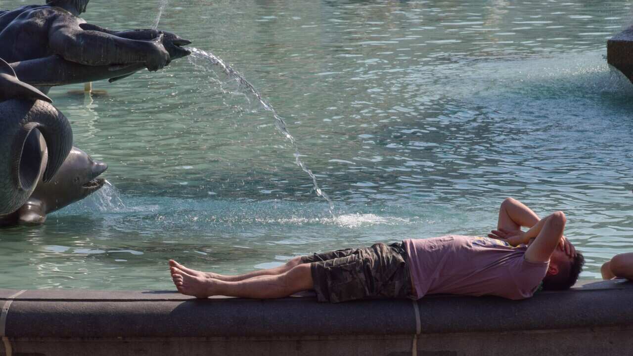 A man lays down next to the fountain at Trafalgar Square as the UK records its highest ever temperatures. The Met Office has issued its first-ever red warning over extreme heat in the UK. (Photo by Vuk Valcic / SOPA Images/Sipa USA)