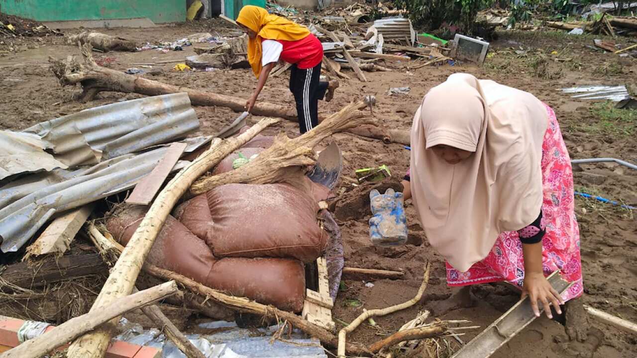 Women clear flood debris in the village in Waiwerang, on Adonara Island, eastern Indonesia, Tuesday, April 6, 2021