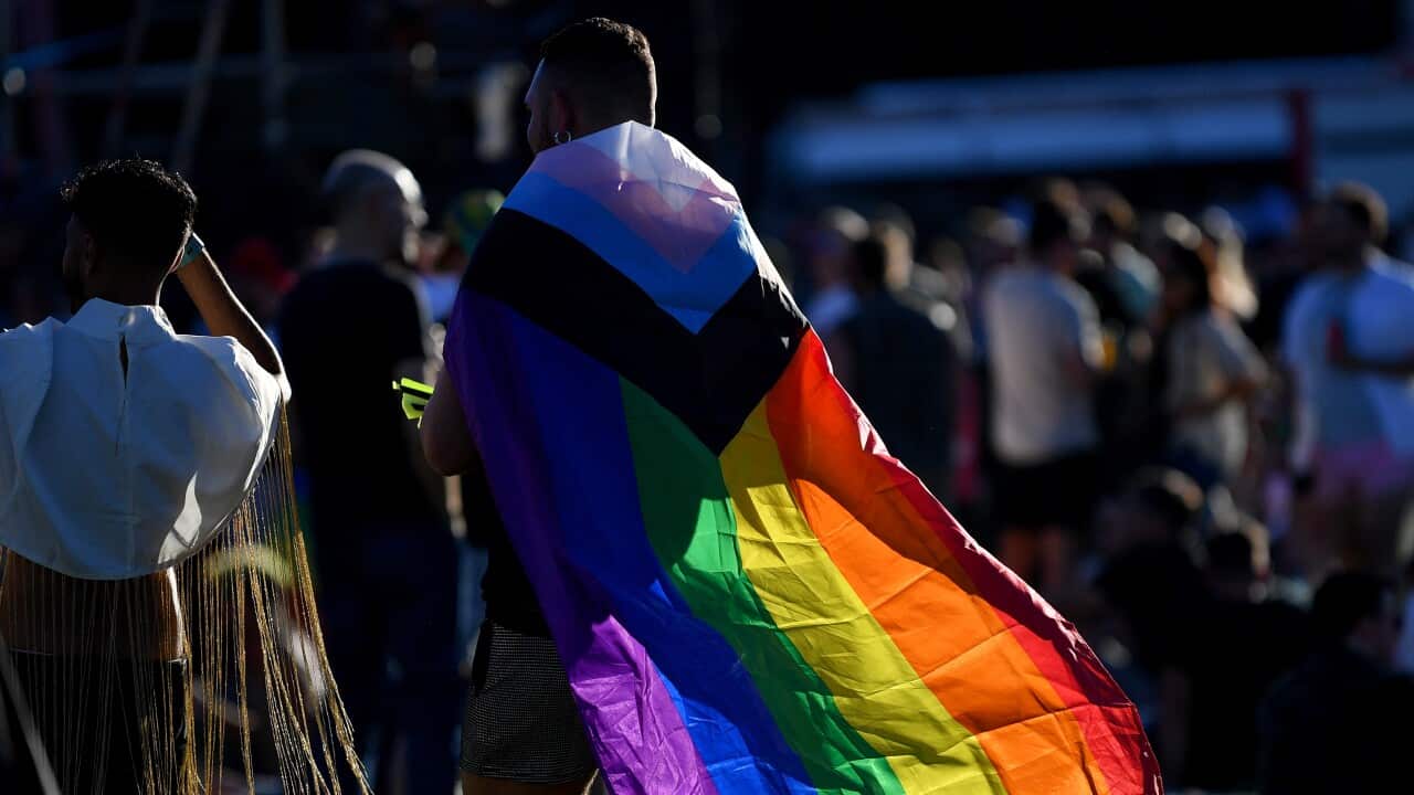 A person wearing a rainbow flag.