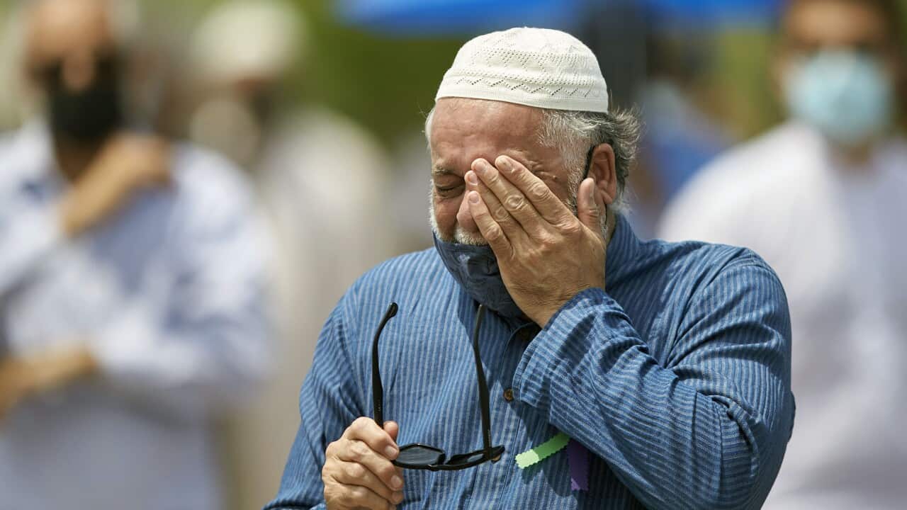 A man wipes away a tear during the funeral service for the four victims of the attack