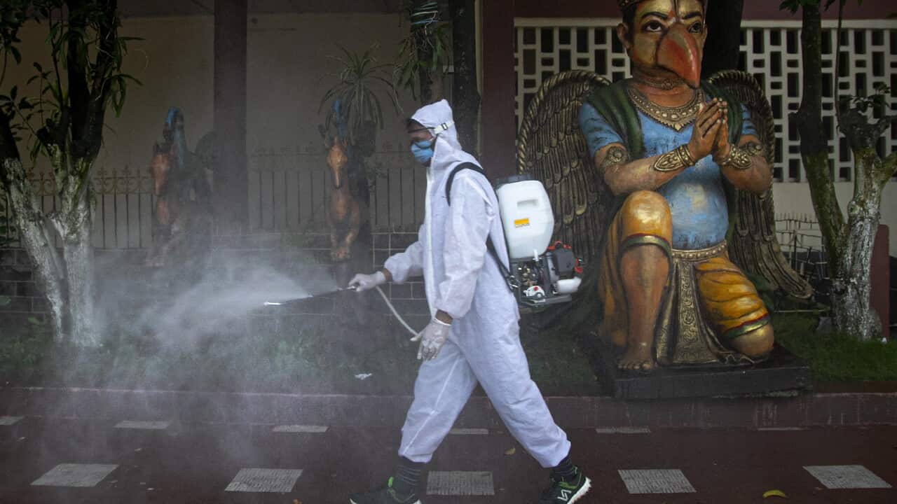 An Indian health worker disinfects an area in Gauhati, India, Thursday, Aug. 13, 2020. India has the third-highest caseload after the United States and Brazil, but only the fifth-highest death toll, and authorities say the fatality rate has dropped below