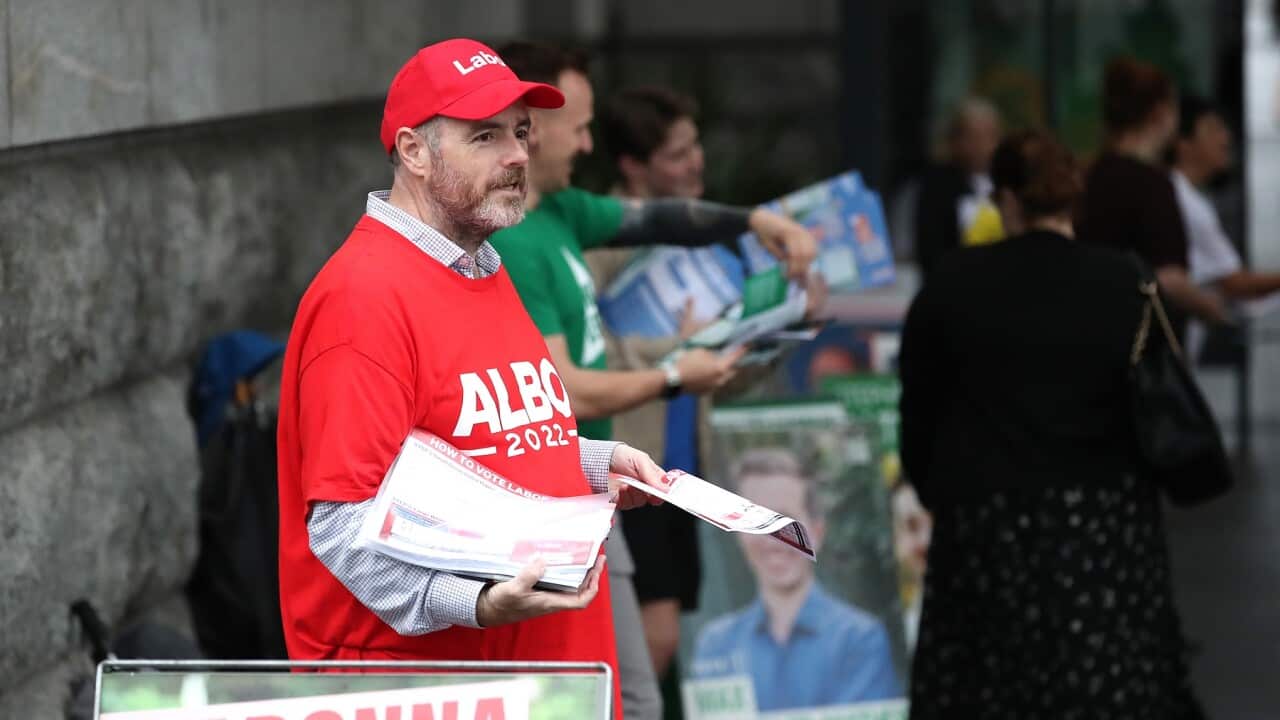 Labor supporter hands out how to vote cards (AAP)