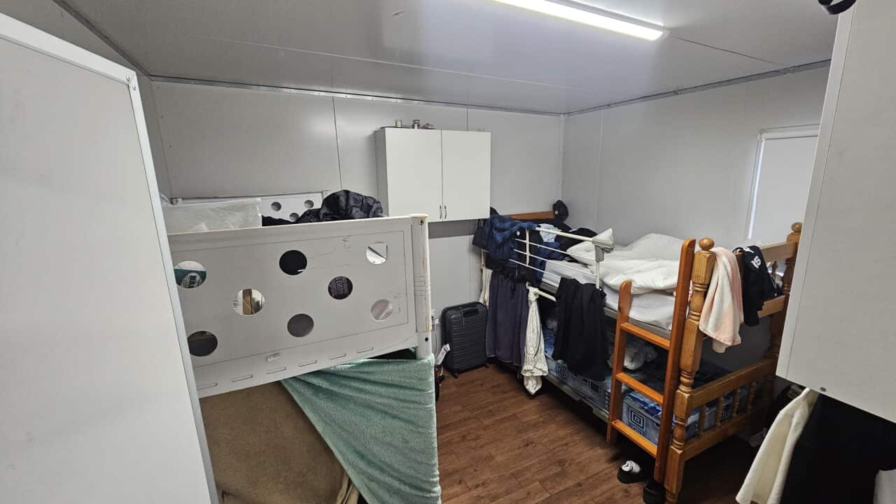 A photo of the inside of a small caravan, fitted with two bunk beds.