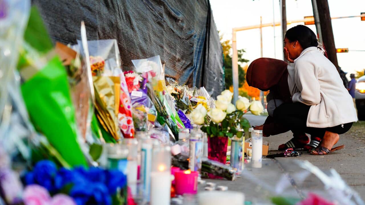 People at a makeshift memorial including flowers and candles for concert goers killed in the Astroworld tragedy