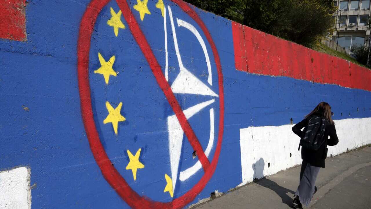 A woman walks past an anti-EU and anti-NATO mural in Belgrade, Serbia, 04 April 2022.