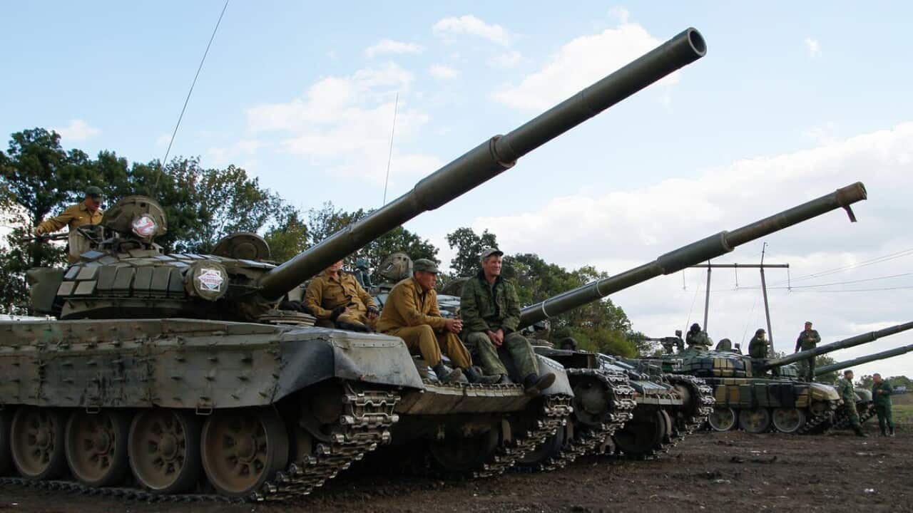 Pro-Russian militants sit on tanks.