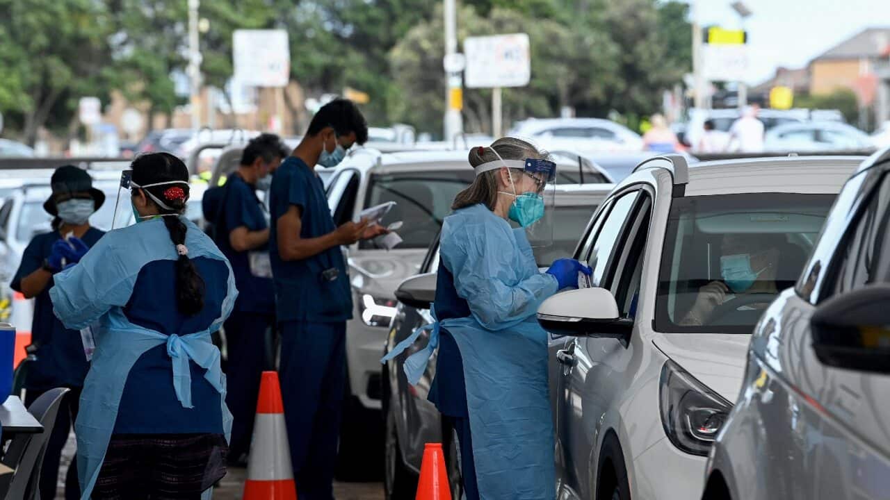 Healthcare workers administer COVID-19 PCR tests at the St Vincent’s Drive-through Clinic at Bondi Beach in Sydney on 1 January 2022.