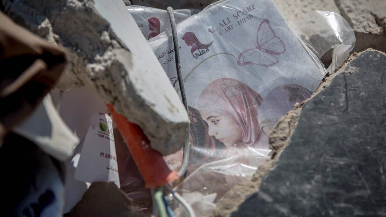 An image of rubble after Israeli Airstrikes Hit Central Jibchit in Nabatieh District, Southern Lebanon. In the rubble is a picture of a Lebanese woman on packaging for a head scarf.