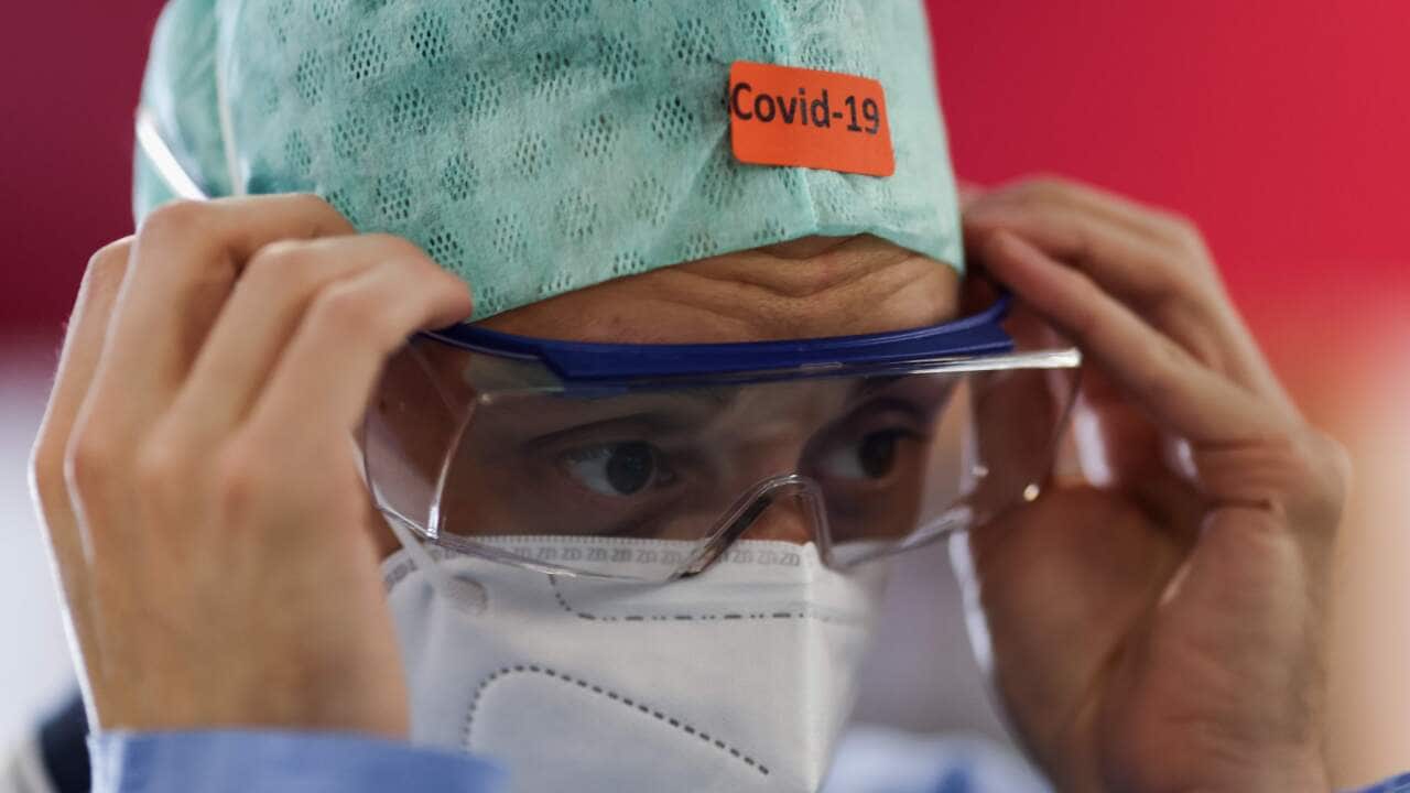 A medical worker puts on his personal protective equipment before work at The University Hospital Centre's intensive care unit in Liege on 22 October.