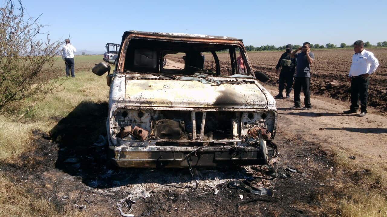 In this Nov. 21, 2015 photo, Mexican authorities inspect a burnt out van suspected to belong to a couple of Australian tourists missing for more than a week, in Sinaloa, Mexico. (AP Photo)
