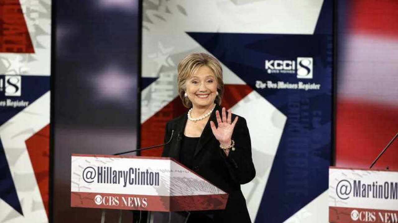 Hillary Rodham Clinton waves during a commercial break at a Democratic presidential primary debate