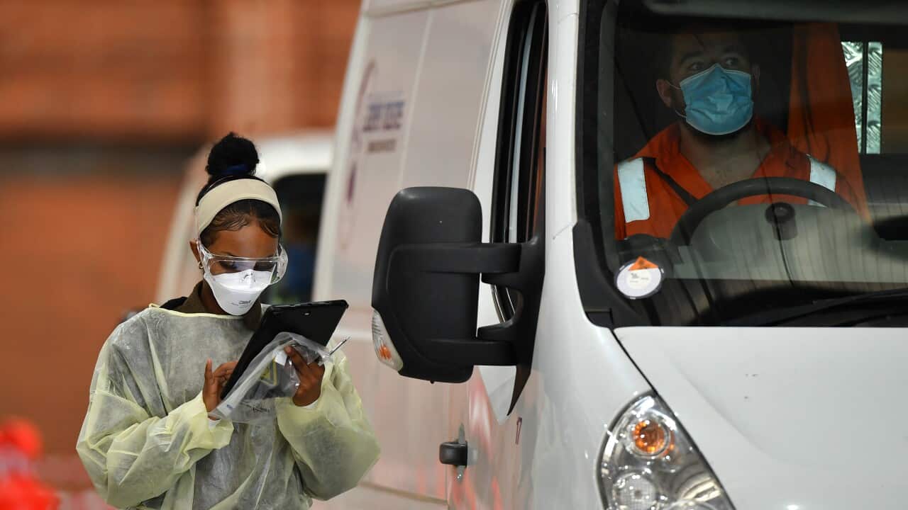 A healthcare worker is seen preparing to take a sample for a COVID-19 test at a testing centre
