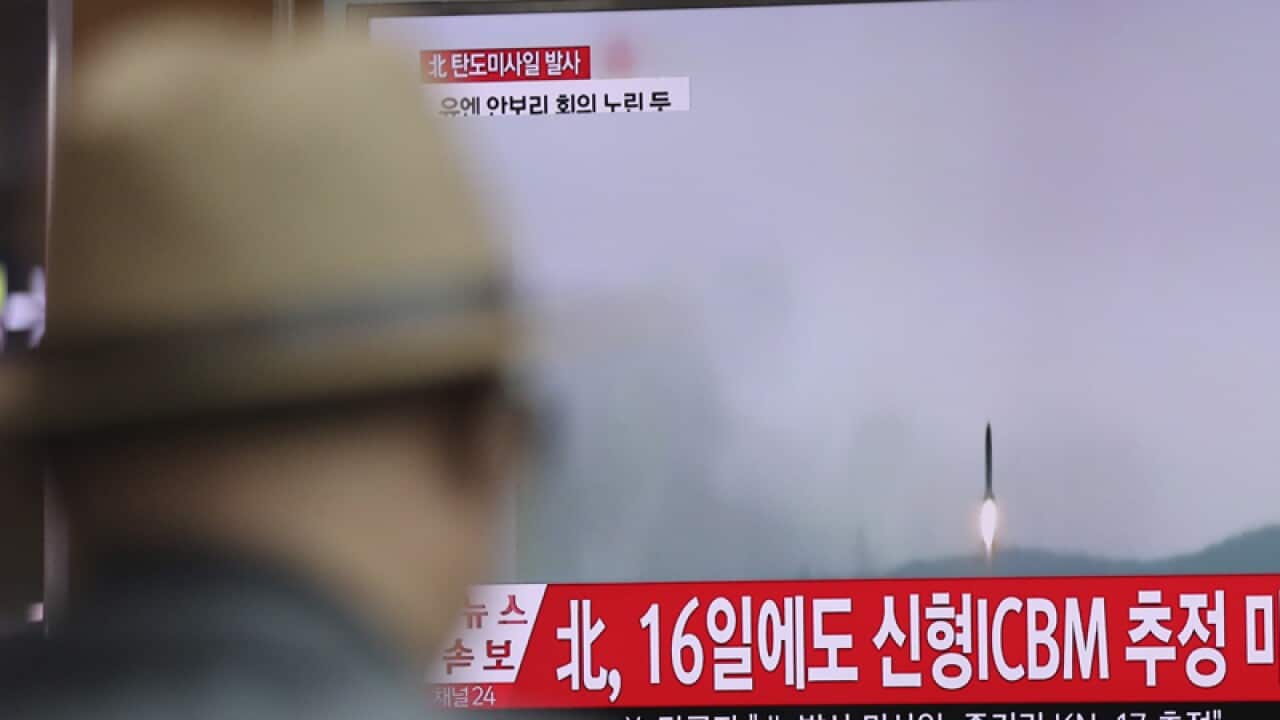 A man watches a TV reporting about North Korea's missile firing