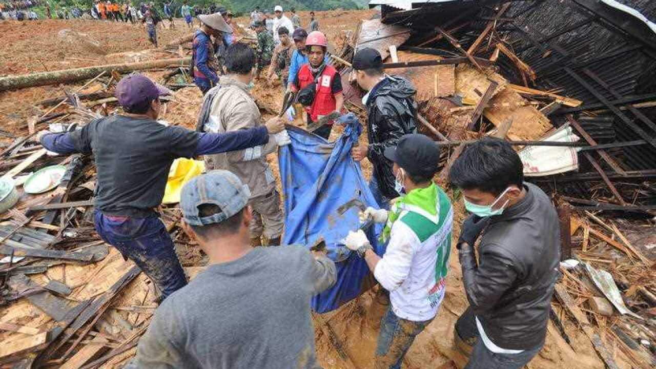 Indonesian rescuers carry the remains of a landslide victim at Sirnaresmi village in Sukabumi, Indonesia.