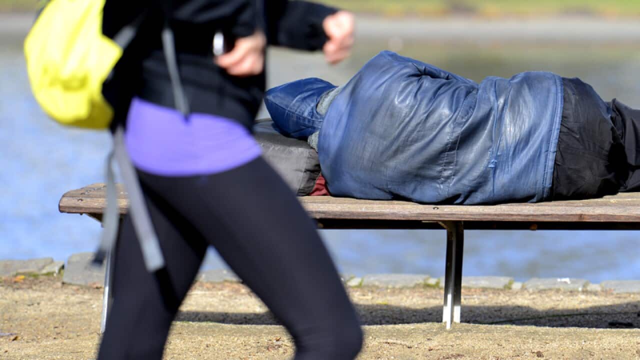 A man sleeps in the sunshine along the Yarra River
