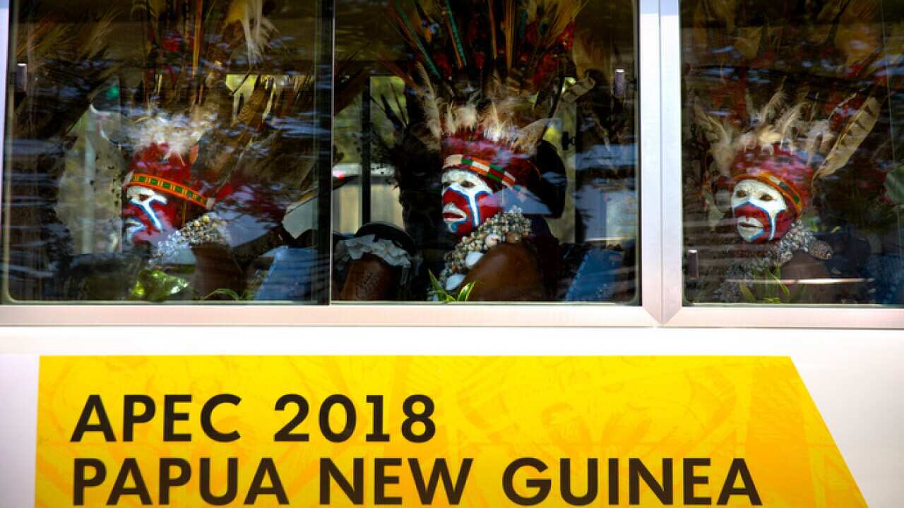 Men in traditional dress ride a shuttle bus ahead of the APEC summit in Papua New Guinea