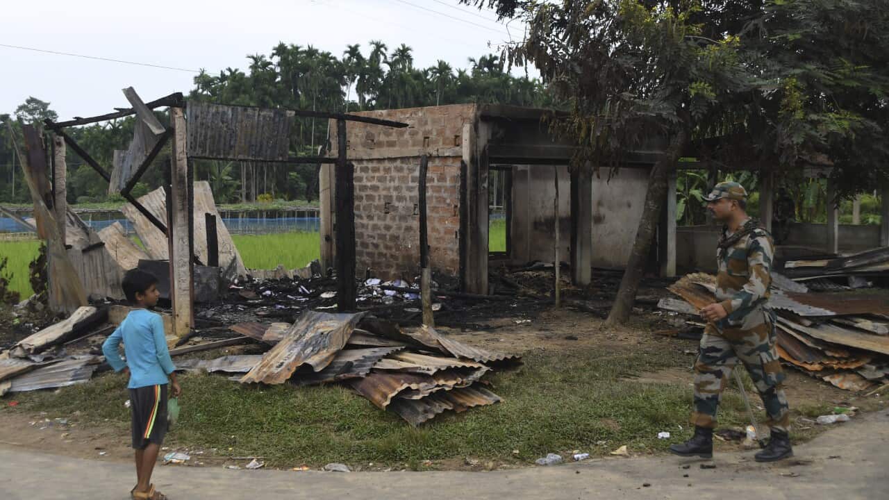 A para military personnel petrol near the burnt shop owned by Muslim people in Rowa village, 220 km from Agartala, India