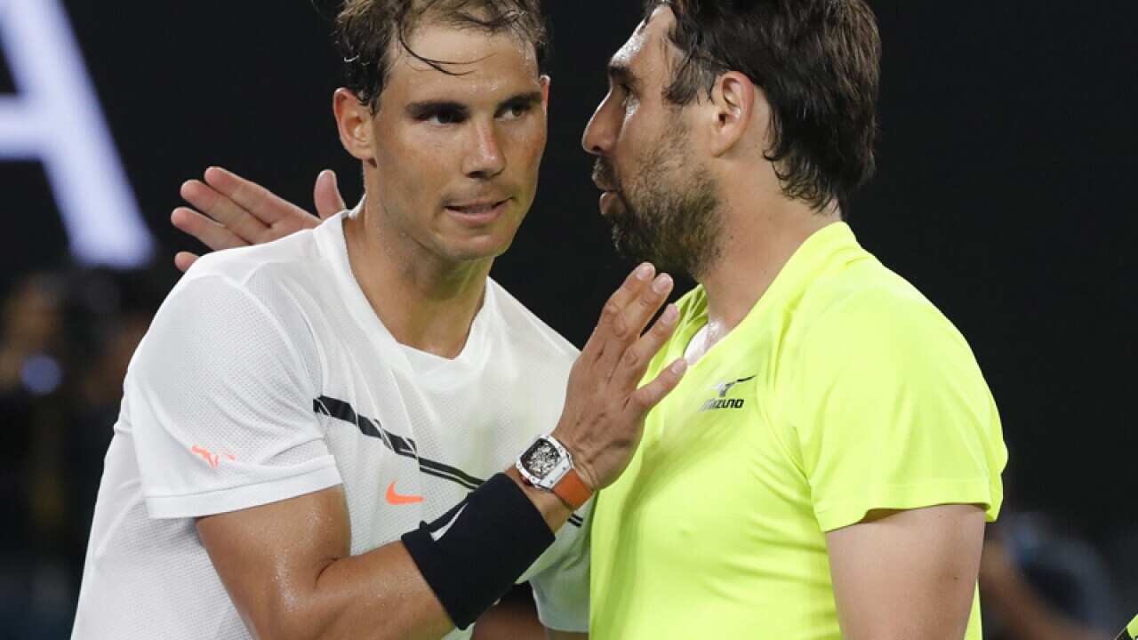 Rafael Nadal of Spain (L) is congratulated by Marcos Baghdatis