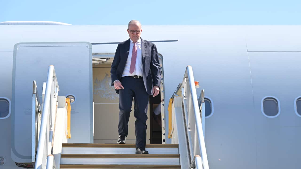 Australian PM Anthony Albanese walking down the stairs off a military aircraft