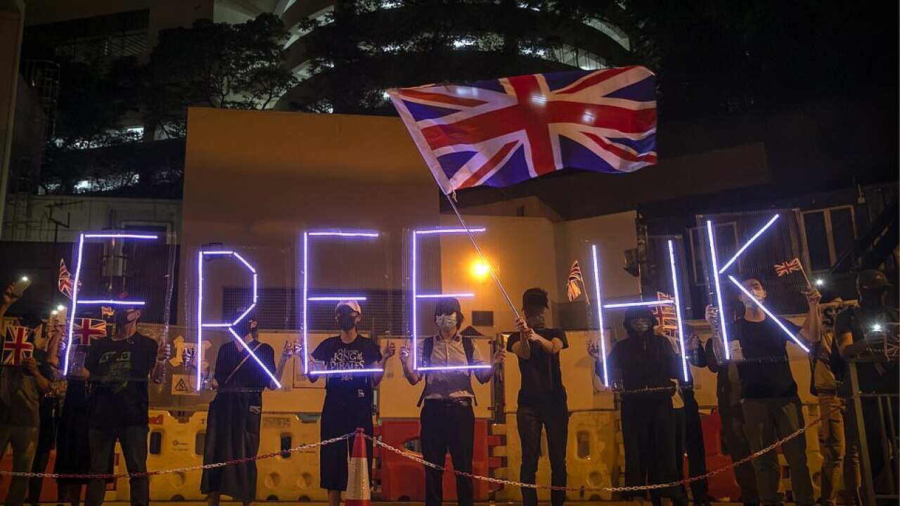 Demonstrators wave a British flag during a rally outside of the British Consulate in Hong Kong on Wednesday night. The UK's House of Lords is due to debate a motion which could potentially grant UK citizenship to residents in the former colony