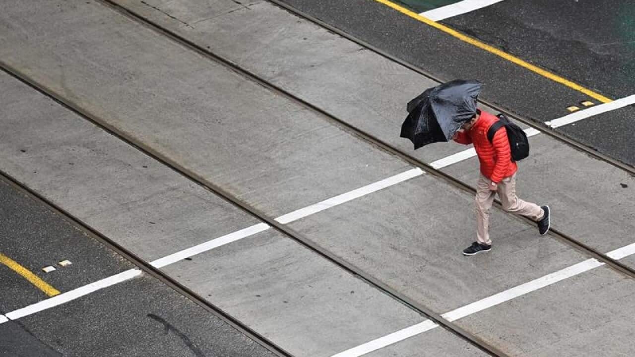 A person is seen crossing Bourke Street in Melbourne.