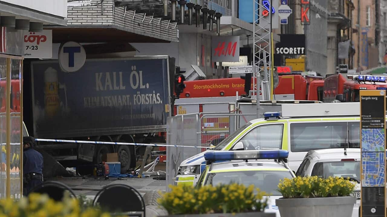 The rear of a truck, left, protrudes after it crashed into a department store injuring several people in central Stockholm, Sweden, Friday April 7, 2017. (Anders Wiklund , TT News Agency via AP)