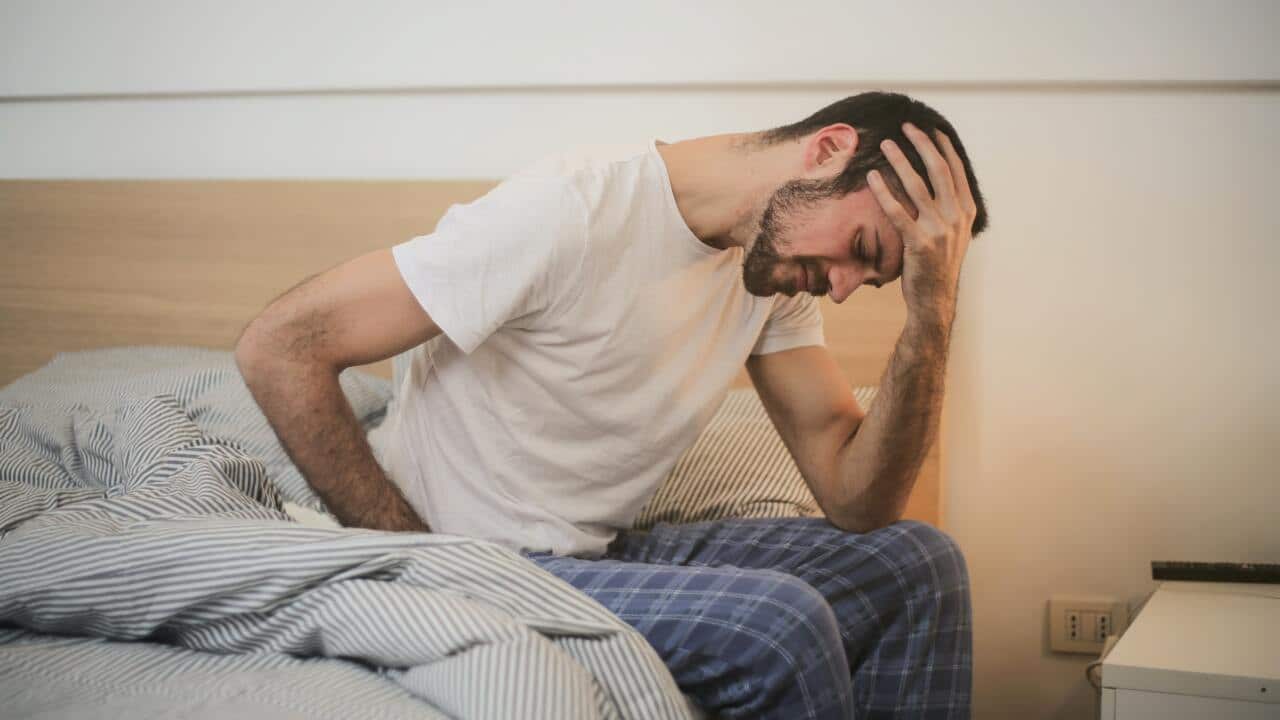 A man suffering headache in bed