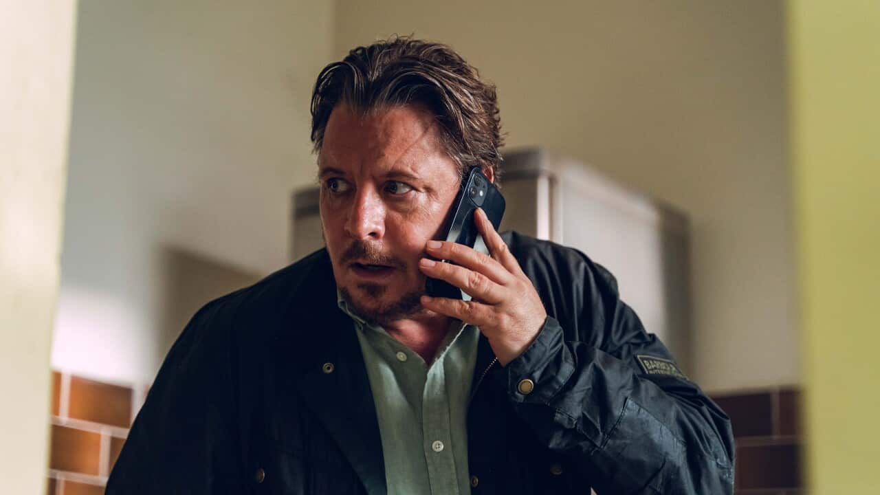 Detective Larsen is on his phone looking stressed in DNA season 2