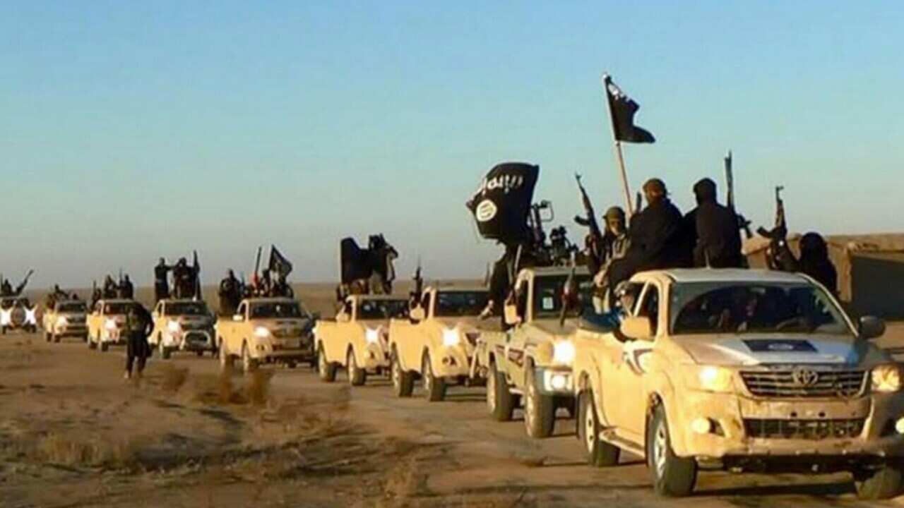 File image posted on an extremist website on Jan. 14, 2014, shows fighters from the Islamic State group marching in Raqqa, Syria (AAP)