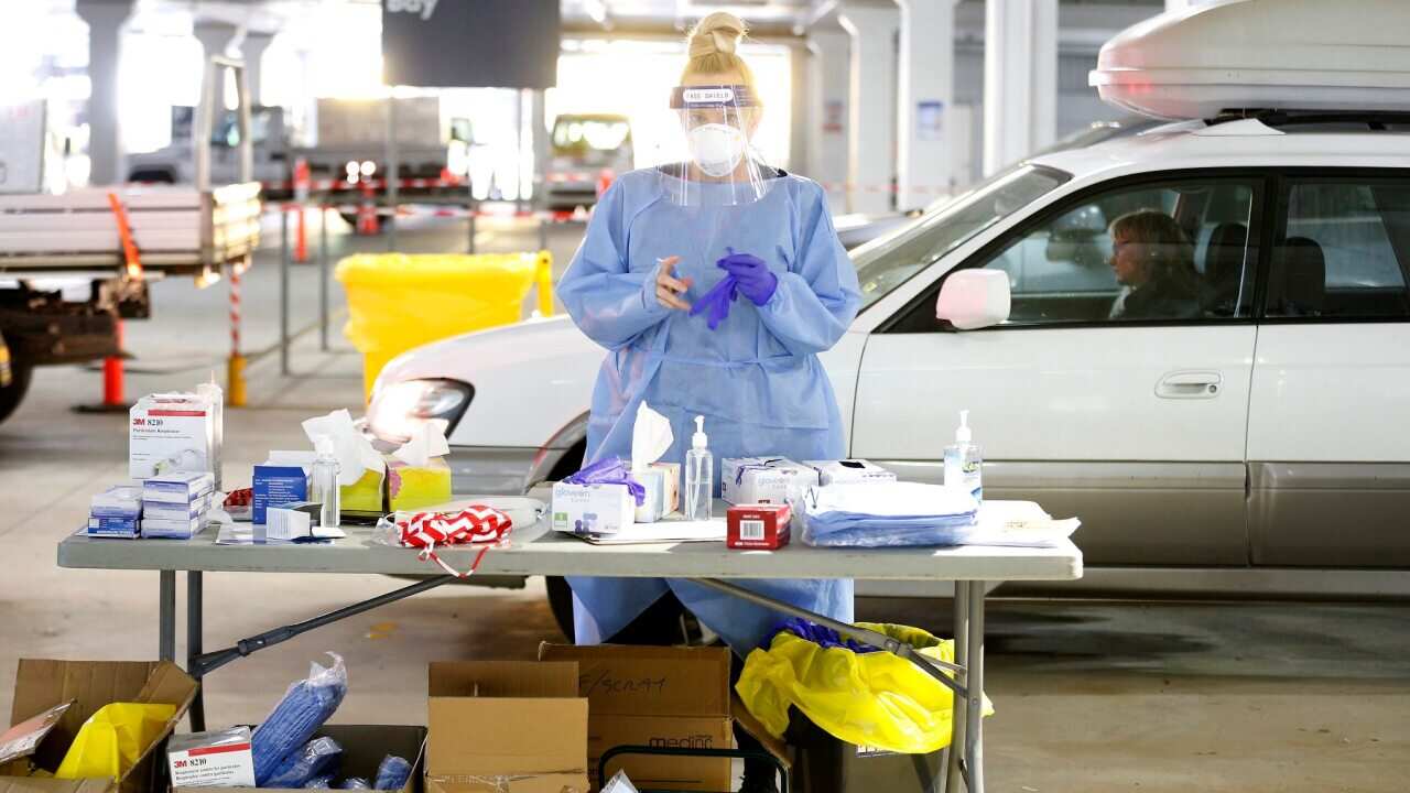 A medical practitioner prepares to administer a test on a member of the public