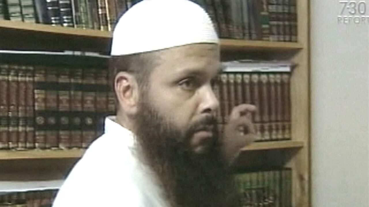 A man standing in front of a bookshelf