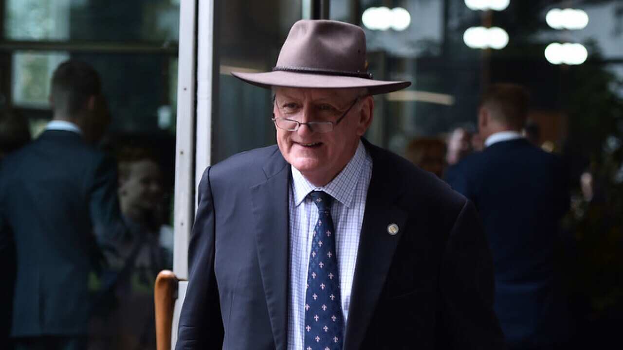 Former Nationals leader Tim Fischer leaves Wilson Hall at Melbourne University after a state memorial for former MP Jim Carlton in Melbourne, Tuesday, Jan.14 2016. (AAP Image/Julian Smith) NO ARCHIVING