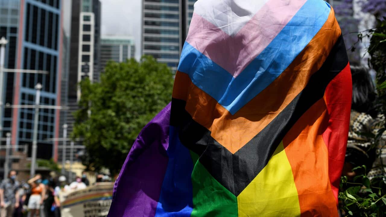 A protester wears a rainbow flag at Sydney Town Hall.