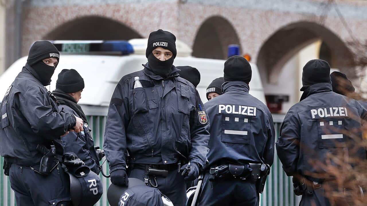 German police officers stand guard in front of a mosque during a terror raid