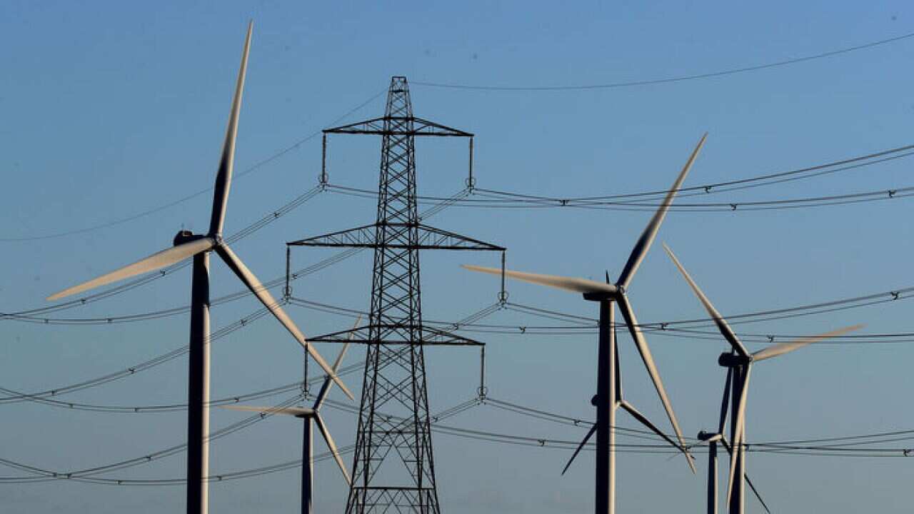 A wind farm amongst electricity pylons