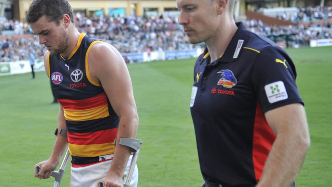 An injured Brad Crouch with coach Brenton Sanderson
