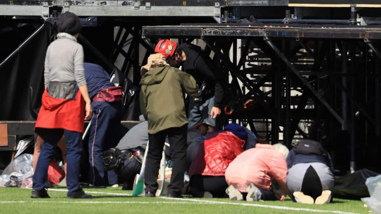Officials remove the Olympic Plate and decorations at a national training centre in Fukushima
