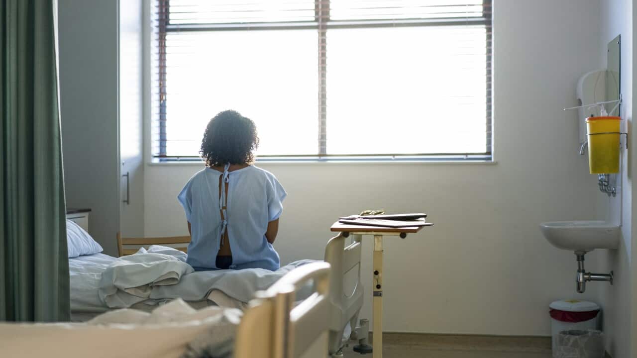 Lonely female patient sitting on hospital bed